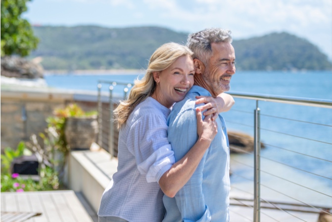 Two people holding one another on a beach.